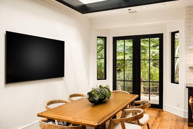 dining area with light hardwood / wood-style floors and french doors