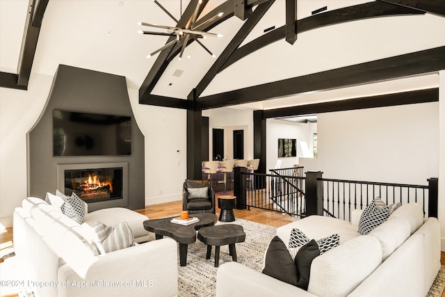 living room with beam ceiling, light wood-type flooring, high vaulted ceiling, and a chandelier