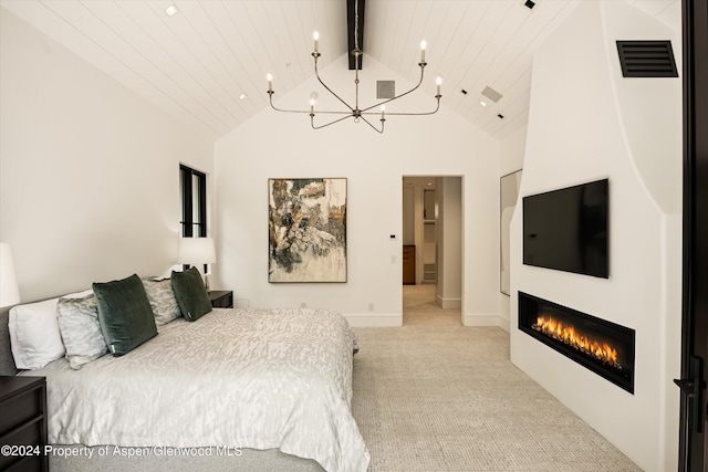 bedroom with a large fireplace, high vaulted ceiling, light colored carpet, and a notable chandelier