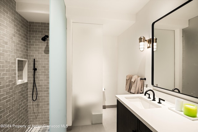 bathroom featuring tiled shower and vanity