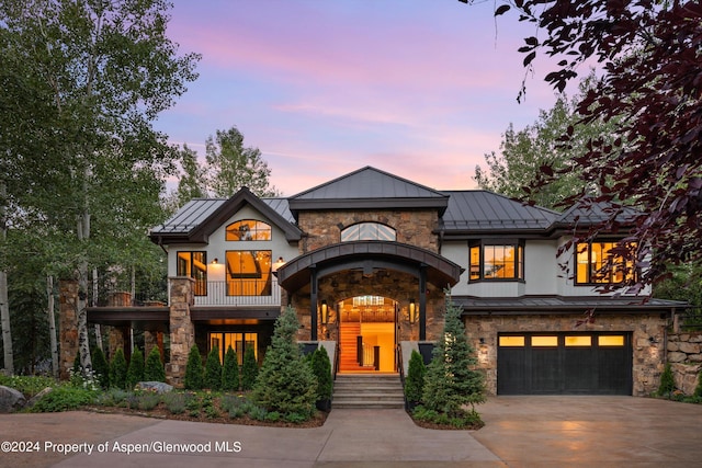 view of front of property featuring a balcony and a garage