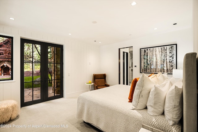 carpeted bedroom featuring wooden walls, access to outside, and french doors