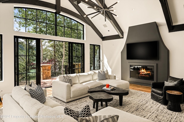 living room with beamed ceiling, wood-type flooring, a notable chandelier, and high vaulted ceiling