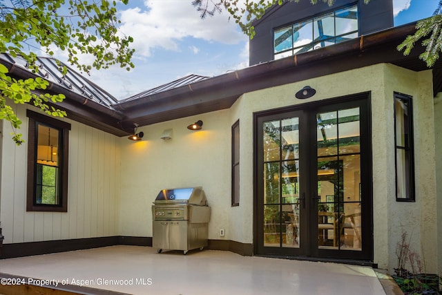 view of exterior entry with a patio area and french doors