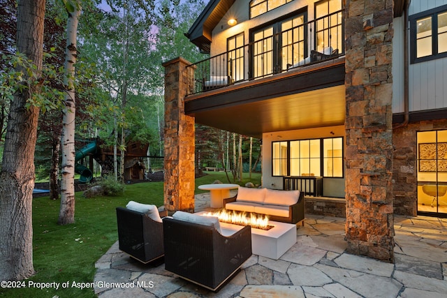 view of patio featuring a balcony and an outdoor living space with a fire pit