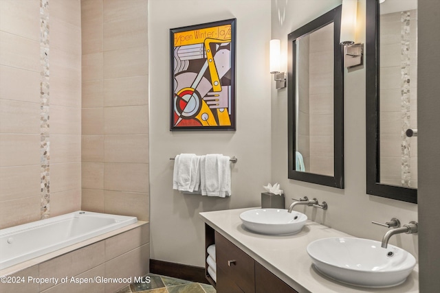 bathroom with vanity and tiled tub