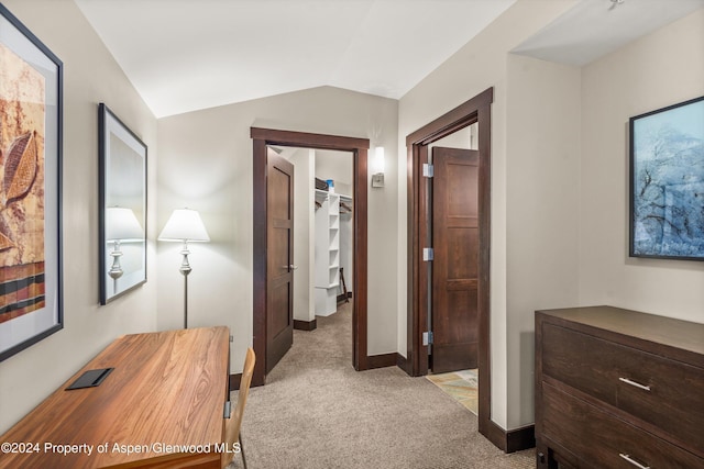 hallway featuring light colored carpet and lofted ceiling