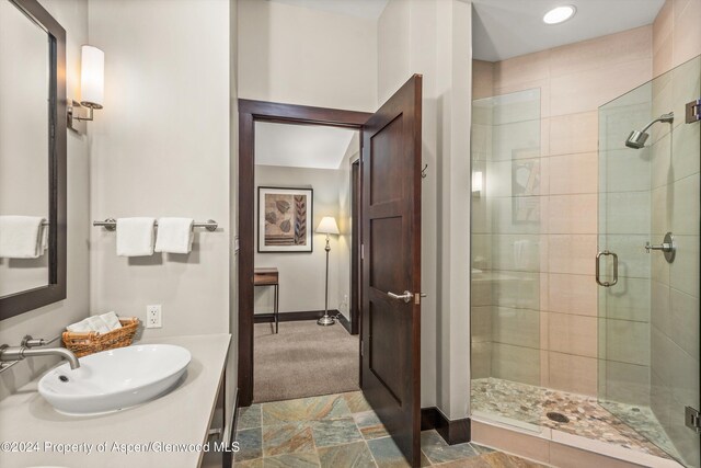 bathroom featuring an enclosed shower and sink