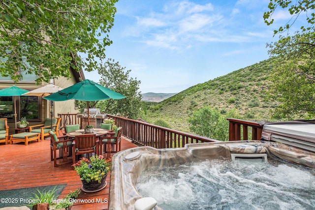 477 Aspen Oak Dr, Aspen, CO 81611 - deck with outdoor dining space, a hot tub, and a mountain view