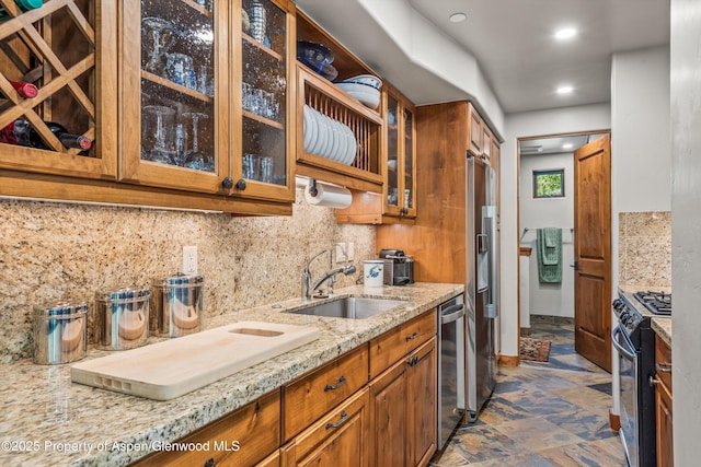 477 Aspen Oak Dr, Aspen, CO 81611 - kitchen featuring appliances with stainless steel finishes, brown cabinetry, light stone countertops, glass insert cabinets, and backsplash