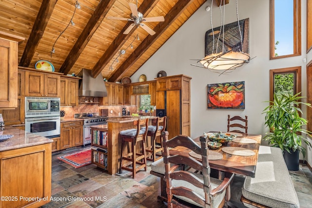 477 Aspen Oak Dr, Aspen, CO 81611 - kitchen with built in appliances, wall chimney range hood, a wooden ceiling with exposed beams, high vaulted ceiling, and stone tile floors