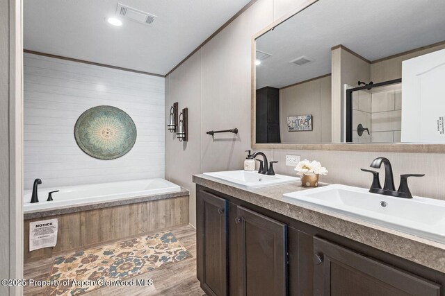 bathroom with a stall shower, visible vents, and a sink