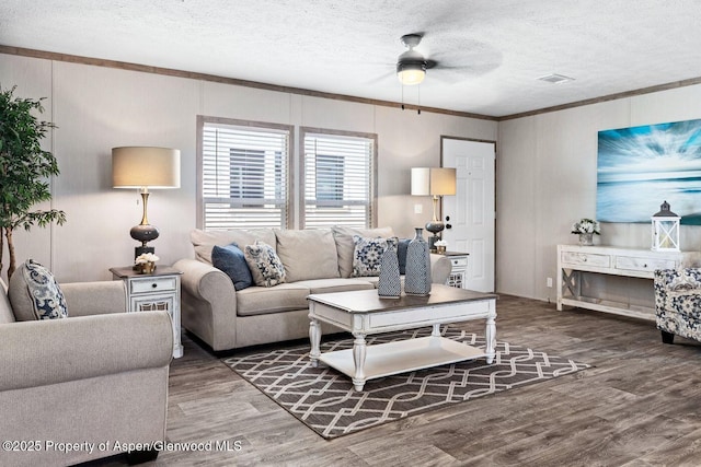 living room with visible vents, ornamental molding, ceiling fan, a textured ceiling, and wood finished floors