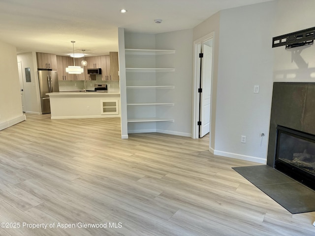 3102 Elk Ln, Basalt, CO 81621 - unfurnished living room with recessed lighting, baseboards, a glass covered fireplace, and light wood-style floors