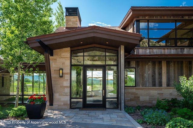425 Aspen Valley Ranch Rd, Woody Creek, CO 81656 - property entrance with a chimney and stone siding