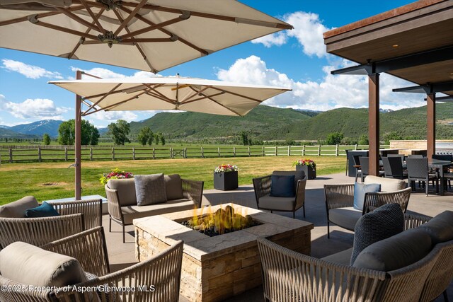 425 Aspen Valley Ranch Rd, Woody Creek, CO 81656 - view of patio / terrace featuring an outdoor living space with a fire pit, a rural view, a mountain view, and outdoor dining space
