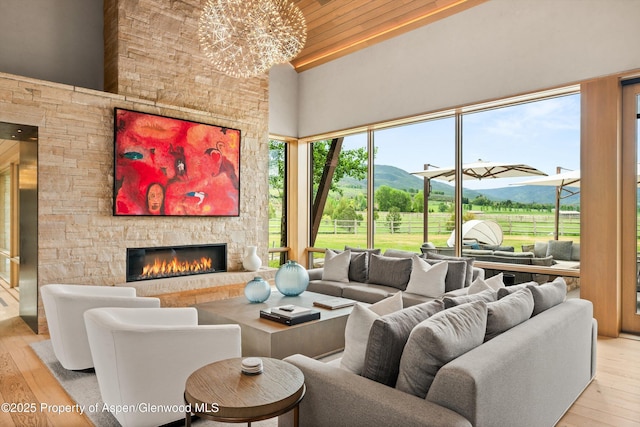 425 Aspen Valley Ranch Rd, Woody Creek, CO 81656 - living area featuring a mountain view, a high ceiling, wood-type flooring, a fireplace, and plenty of natural light