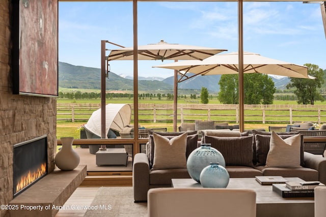 425 Aspen Valley Ranch Rd, Woody Creek, CO 81656 - view of patio / terrace with a view of rural / pastoral area, an outdoor living space with a fireplace, and a mountain view