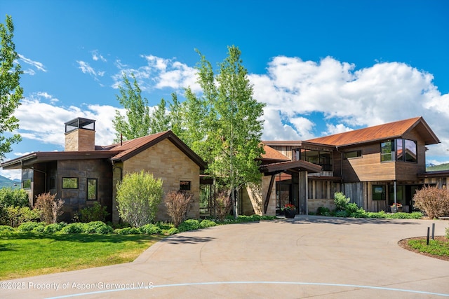 425 Aspen Valley Ranch Rd, Woody Creek, CO 81656 - contemporary home with stone siding, a chimney, metal roof, and curved driveway