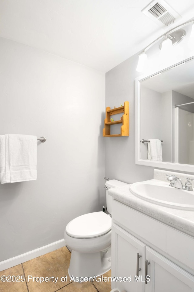 bathroom with tile patterned floors, walk in shower, vanity, and toilet