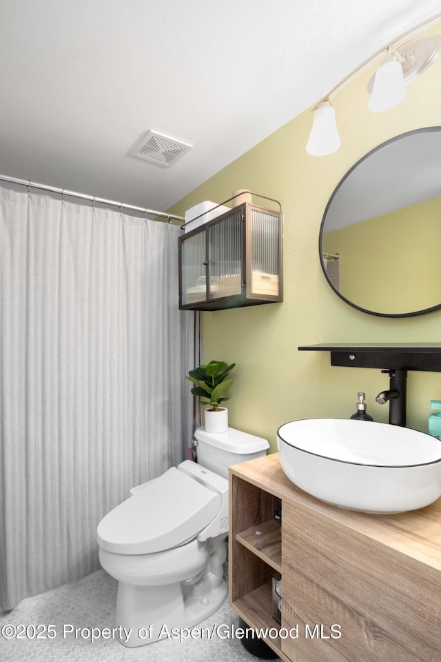 bathroom featuring tile patterned flooring, vanity, and toilet