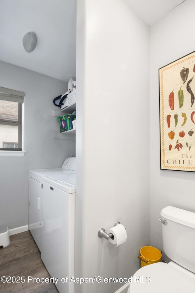 bathroom with hardwood / wood-style floors, toilet, and independent washer and dryer