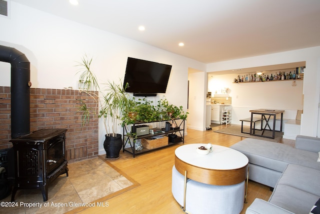 living room featuring wood-type flooring and a wood stove