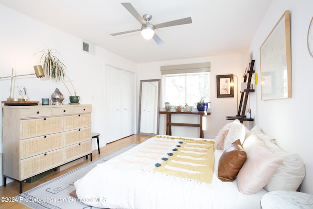 bedroom with ceiling fan, wood-type flooring, and a closet