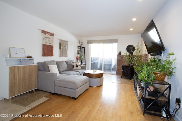 living room featuring a wood stove and light hardwood / wood-style flooring