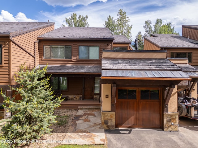 52 Harleston Grn Unit 38, Snowmass Village, CO 81615 - chalet / cabin with covered porch, stone siding, asphalt driveway, and a garage