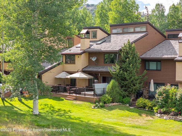 52 Harleston Grn Unit 38, Snowmass Village, CO 81615 - back of house with a yard, a deck, a chimney, stucco siding, and a high end roof