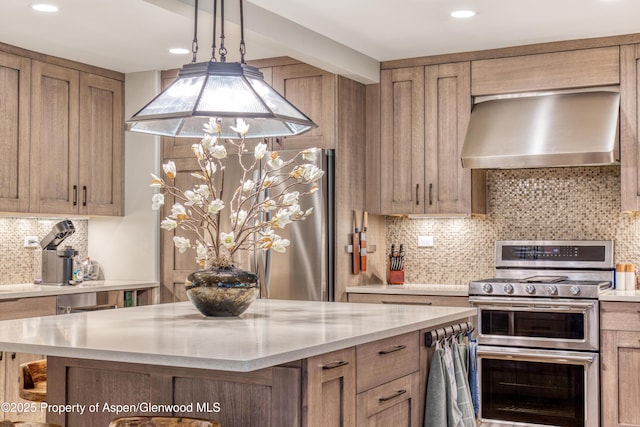 52 Harleston Grn Unit 38, Snowmass Village, CO 81615 - kitchen with wall chimney exhaust hood, double oven range, backsplash, a kitchen island, and island exhaust hood
