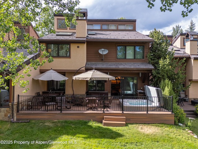 52 Harleston Grn Unit 38, Snowmass Village, CO 81615 - back of house with stucco siding, a deck, a high end roof, and a lawn