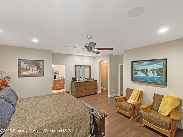 bedroom with arched walkways, wood finished floors, recessed lighting, ceiling fan, and baseboards