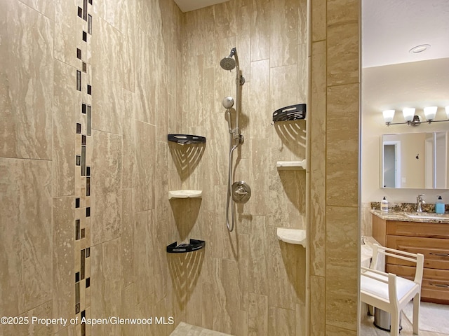 bathroom featuring a tile shower and vanity