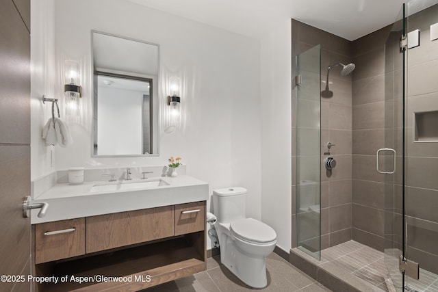 full bathroom with vanity, toilet, a shower stall, and tile patterned flooring