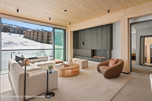 living area with wooden ceiling and a lit fireplace