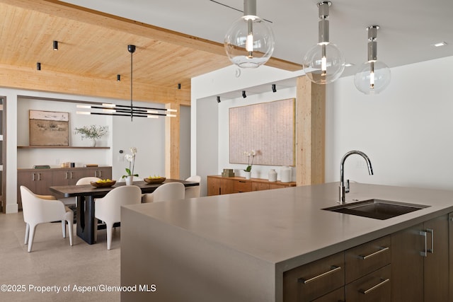 kitchen featuring a sink, wood ceiling, and hanging light fixtures