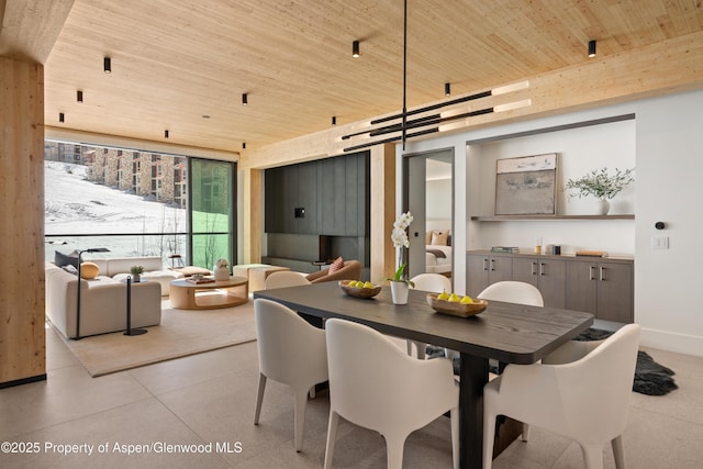 dining space with baseboards and wooden ceiling