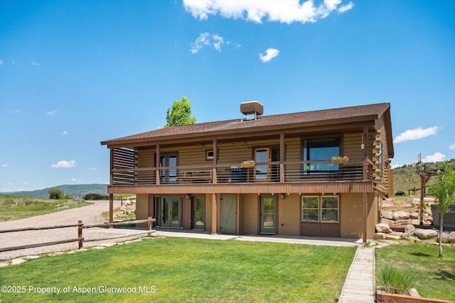 248 Basalt Mountain Dr, Carbondale, CO 81623 - back of property featuring log siding, a lawn, a balcony, and a patio area