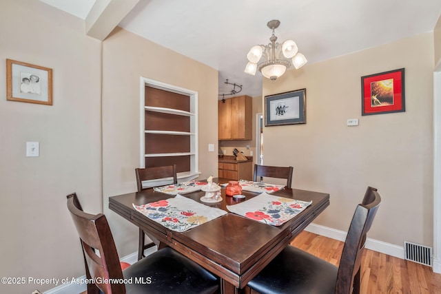 668 Taylor St, Craig, CO 81625 - dining room with an inviting chandelier, baseboards, visible vents, and light wood-style floors