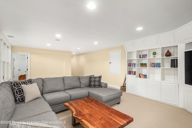 living area featuring baseboards, recessed lighting, visible vents, and light colored carpet