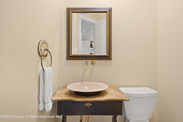 half bathroom with vanity and toilet