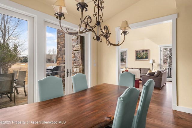 dining space featuring vaulted ceiling and wood finished floors