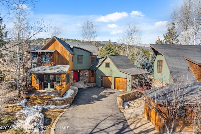 view of front of property featuring driveway and stone siding