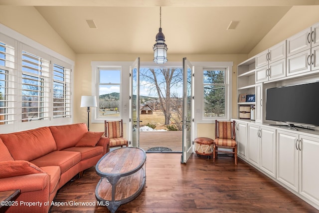 living area featuring visible vents, vaulted ceiling, and dark wood-style flooring