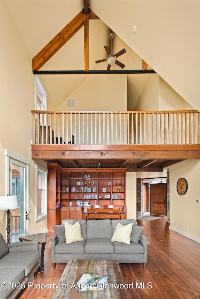 living room featuring visible vents, high vaulted ceiling, wood finished floors, and beamed ceiling