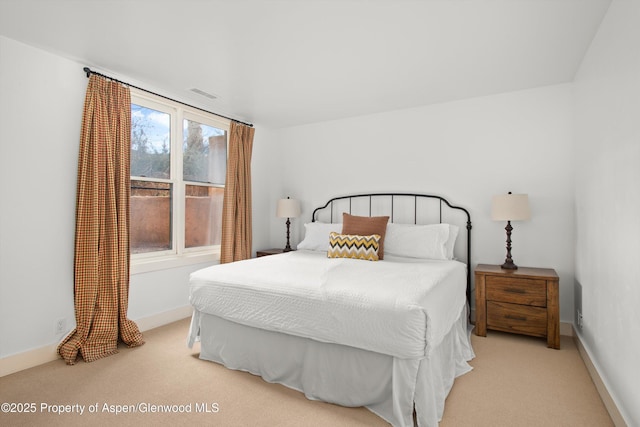 bedroom featuring baseboards, visible vents, and light colored carpet