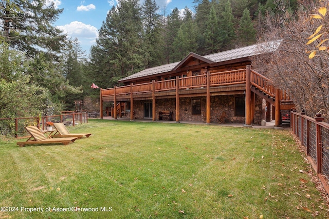 rear view of property with a yard and a deck