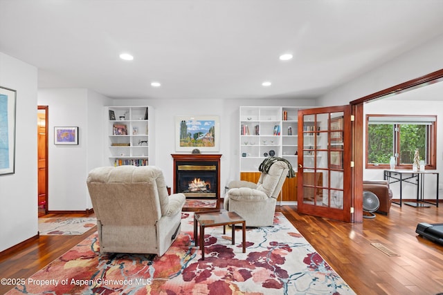 309 Deer Run, Carbondale, CO 81623 - living area with wood finished floors, a warm lit fireplace, recessed lighting, french doors, and built in features